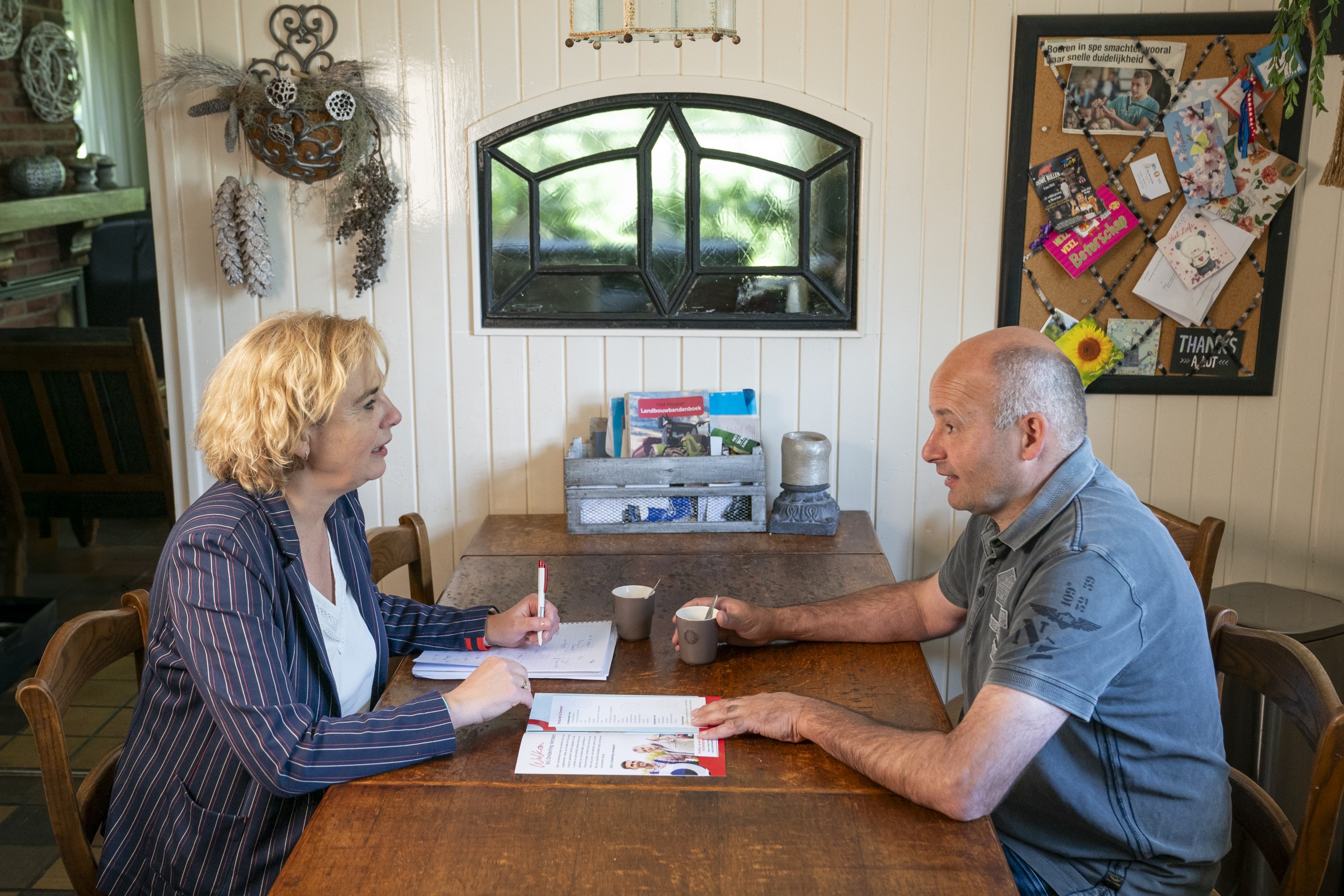 Klantadviseur zit bij agrariër aan de keukentafel. Onderling Verzekerd