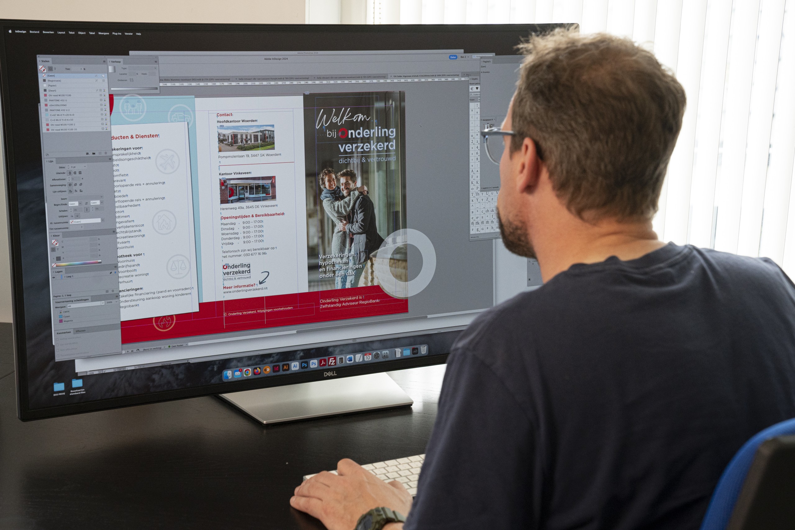 Vormgever aan het werk met folder. Onderling Verzekerd